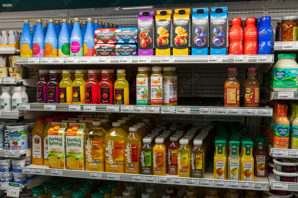 Orange juice, apple juice and assorted juices on a shelf at a market in