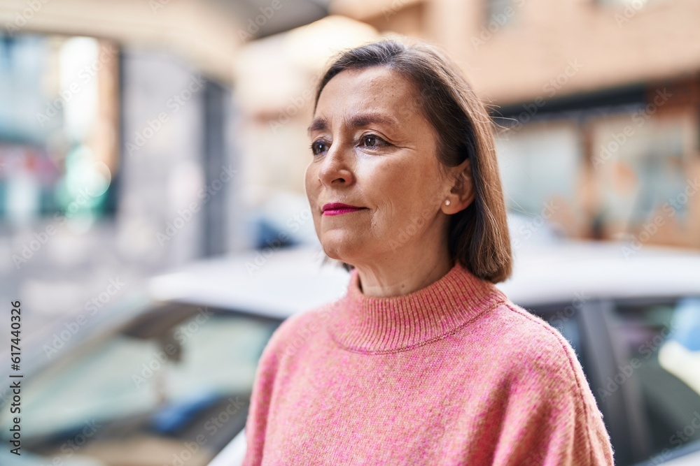 Middle age woman with relaxed expression standing at street Middle age woman with relaxed expression standing at street