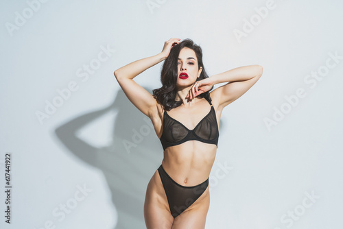 Image of a beautiful woman posing in lingerie on a white background