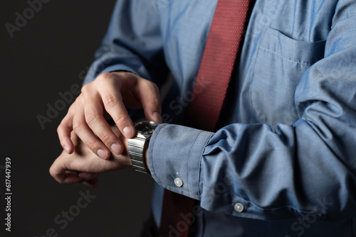 腕時計を確認するビジネスマン