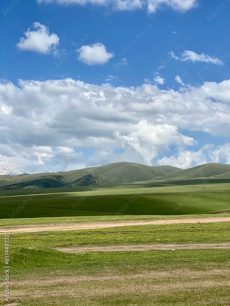 field and blue sky. green field and blue sky. Landscapes in the mountains. landscape with clouds in the mountains of Kazakhstan, Almaty. Tourism development in Kazakhstan