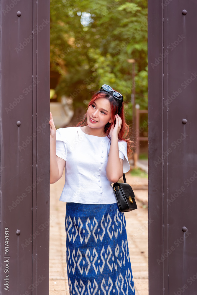 Young Asian women dressed in traditional costumes visit an old temple ...