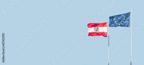 Photography Banner with two flags of EU and Austria standing in wind together at blue sky so