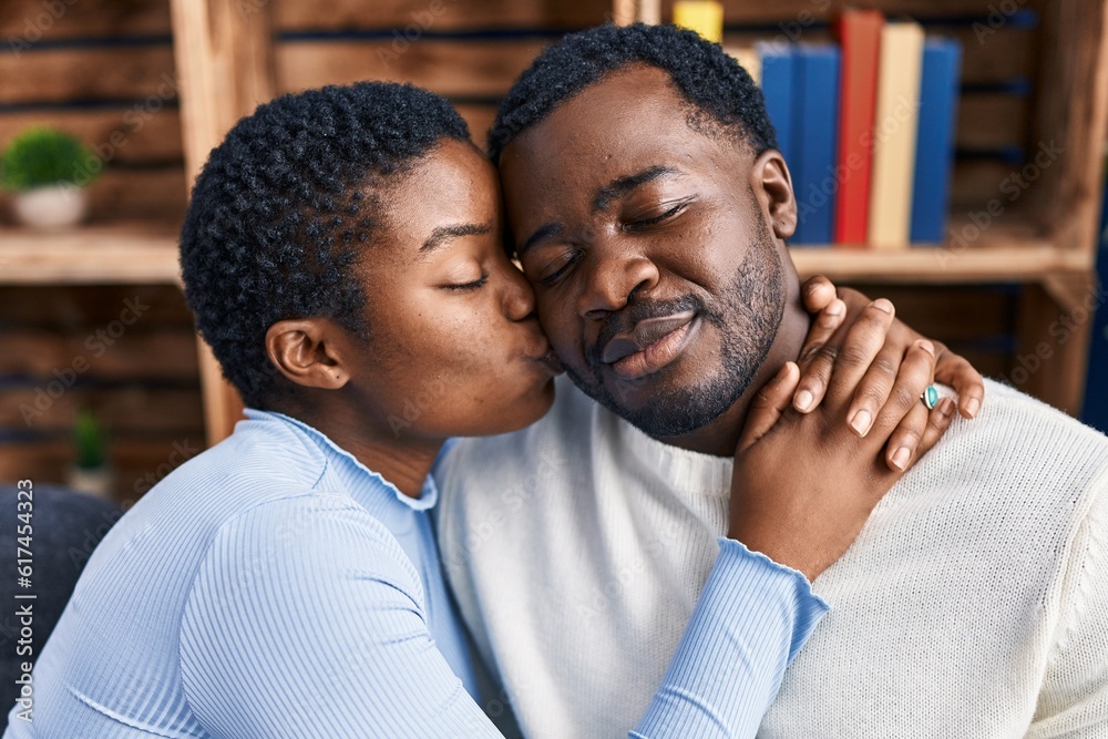 Man and woman couple hugging each other sitting on sofa at home Man and woman couple hugging each other sitting on sofa at home