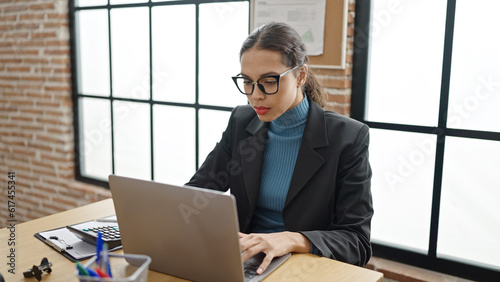 Young beautiful hispanic woman business worker using laptop working at office