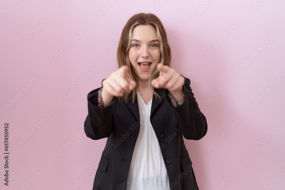 Young caucasian business woman wearing black jacket pointing to you and the camera with fingers, smiling positive and cheerful Young caucasian business woman wearing black jacket pointing to you and the camera with fingers, smiling positive and cheerful