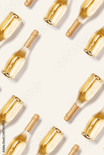 Canvas Print Flat lay top view frame of bottles of white sparkling wine, glass champagne bottle on beige background