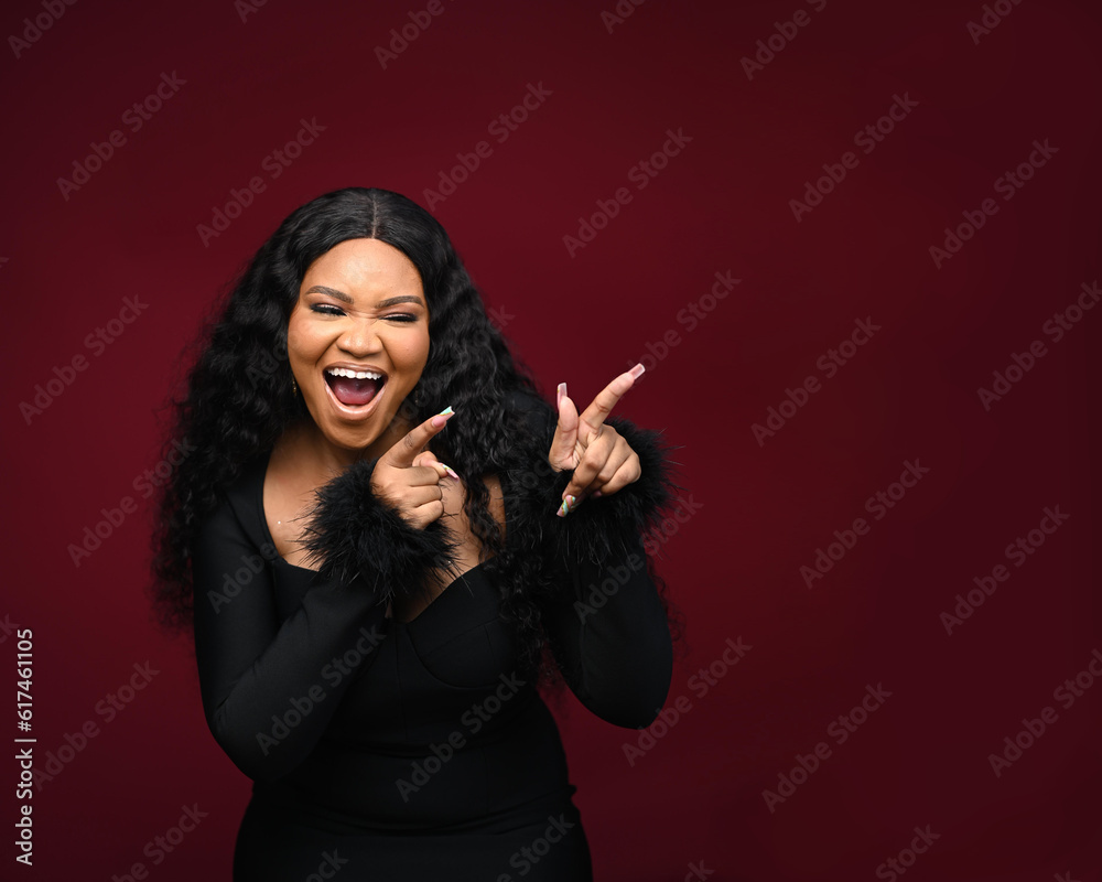 An excited African woman shouts out loud wow with her hands on isolated white background. Happy shocked face female wow promotion advertising concept. Joyful teenage girl standing in a red room.