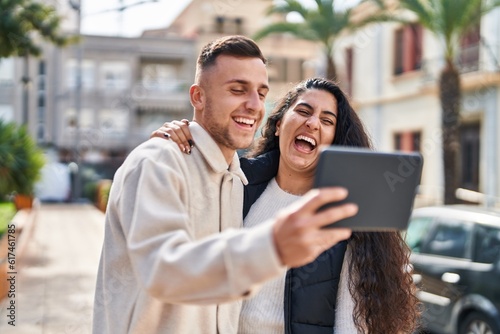 Man and woman smiling confident using touchpad at street