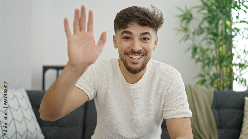 Young arab man having video call sitting on sofa at home Young arab man having video call sitting on sofa at home