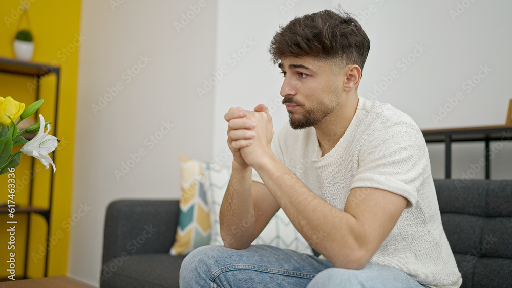 Young arab man sitting on sofa with relaxed expression at home Young arab man sitting on sofa with relaxed expression at home