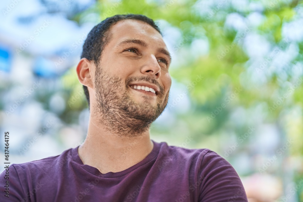 Young man smiling confident looking to the side at park