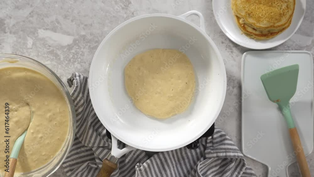 Flat lay. Frying coconut banana pancakes on a nonstick white frying pan. Flat lay. Frying coconut banana pancakes on a nonstick white frying pan.