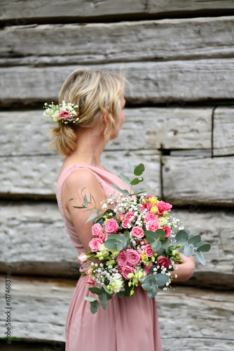 a young girl in a pink dress holds a bouquet