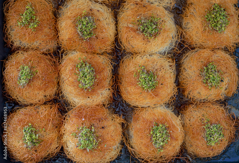 close up turkish dessert kadayif. shredded wheat dessert with pistachio filling