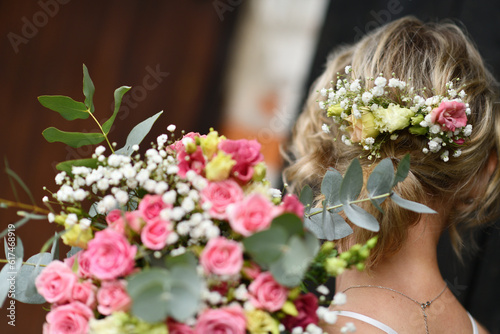 bride with a bouquet of roses in her hands and hair