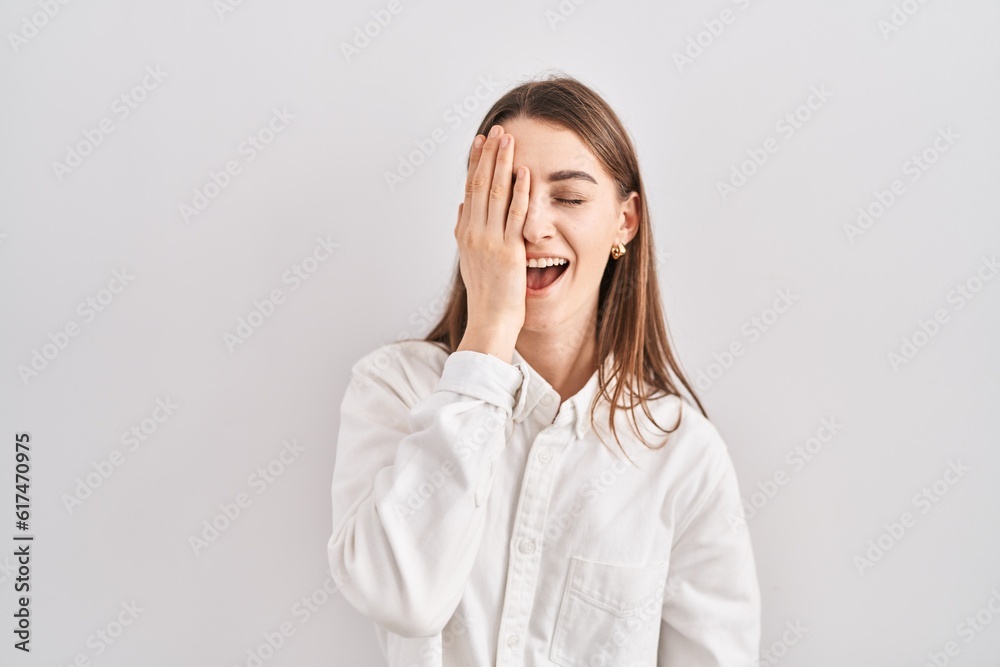 Young caucasian woman standing over isolated background yawning tired covering half face, eye and mouth with hand. face hurts in pain. Young caucasian woman standing over isolated background yawning tired covering half face, eye and mouth with hand. face hurts in pain.
