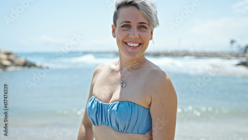 Young woman tourist wearing bikini smiling at beach