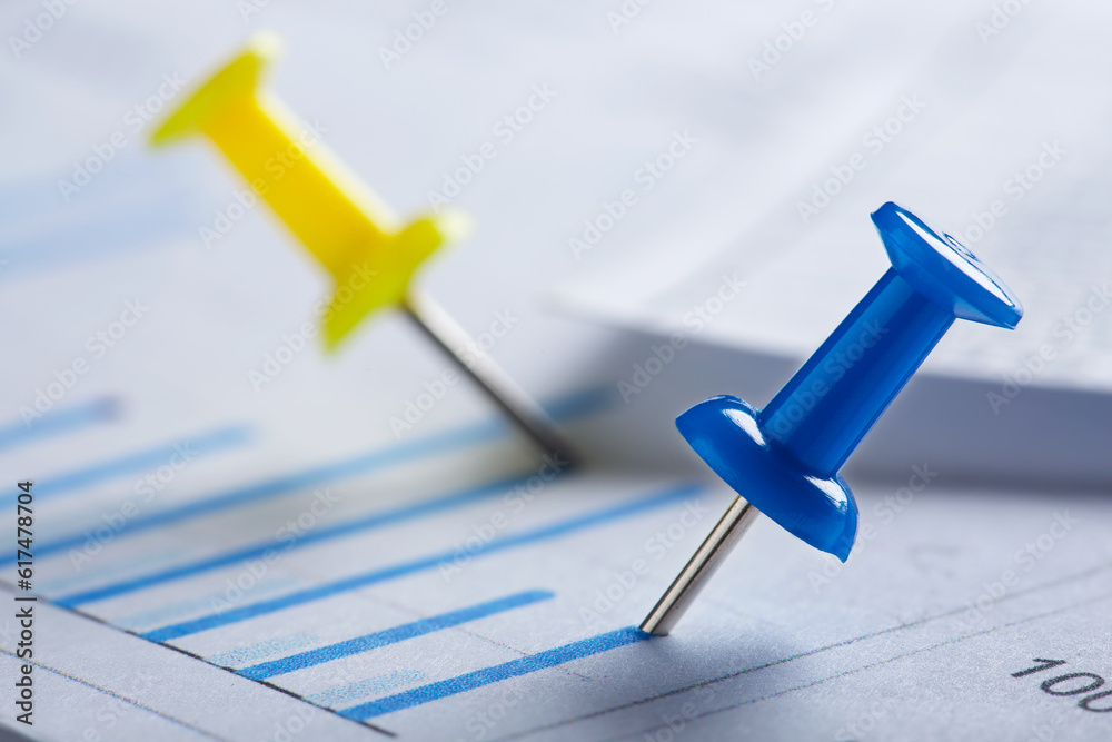 Marking financial chart by pins.Share listing and checking financial chart. Concept of banking, financial report and financial audit. Marking financial chart by pins.Share listing and checking financial chart. Concept of banking, financial report and financial audit.
