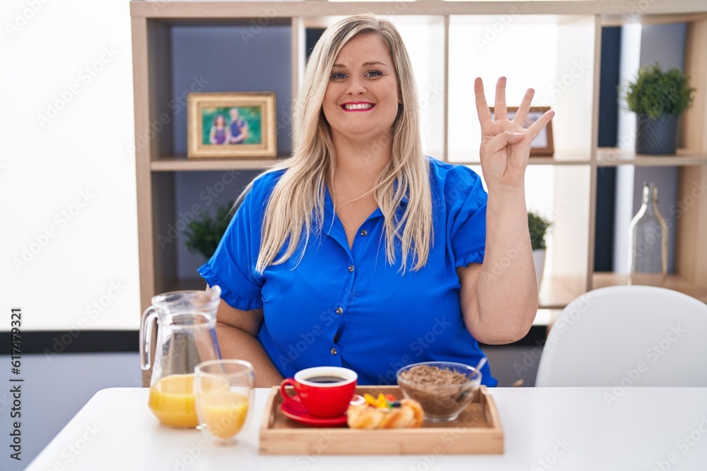Caucasian plus size woman eating breakfast at home showing and pointing up with fingers number four while smiling confident and happy. Caucasian plus size woman eating breakfast at home showing and pointing up with fingers number four while smiling confident and happy.