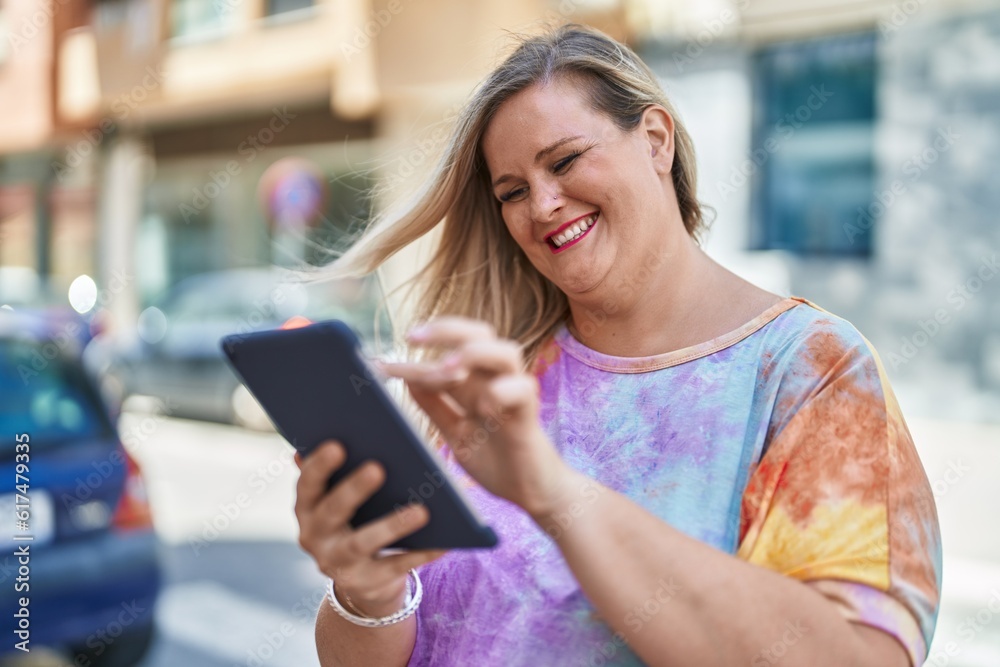 Young woman smiling confident using touchpad at street