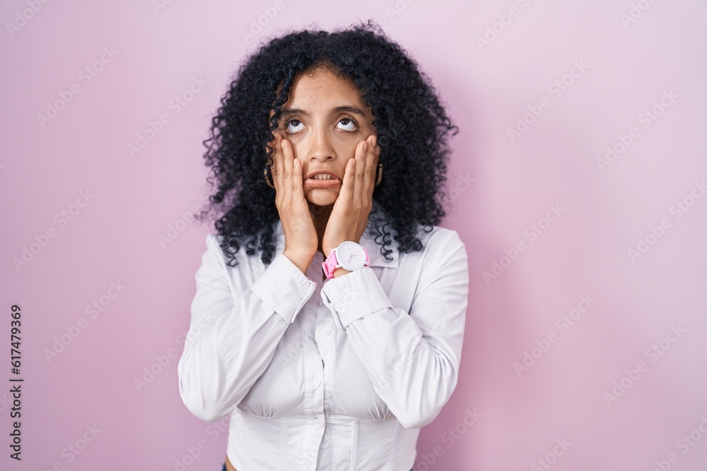 Hispanic woman with curly hair standing over pink background tired hands covering face, depression and sadness, upset and irritated for problem Hispanic woman with curly hair standing over pink background tired hands covering face, depression and sadness, upset and irritated for problem