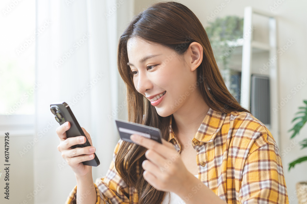 Bill pay, shopping order online internet asian young woman hand holding credit card and mobile smart phone on desk at home, female using banking service to secure payment with purchase on store. Bill pay, shopping order online internet asian young woman hand holding credit card and mobile smart phone on desk at home, female using banking service to secure payment with purchase on store.