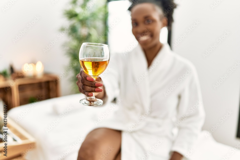 African american woman wearing bathrobe drinking champagne at beauty salon African american woman wearing bathrobe drinking champagne at beauty salon