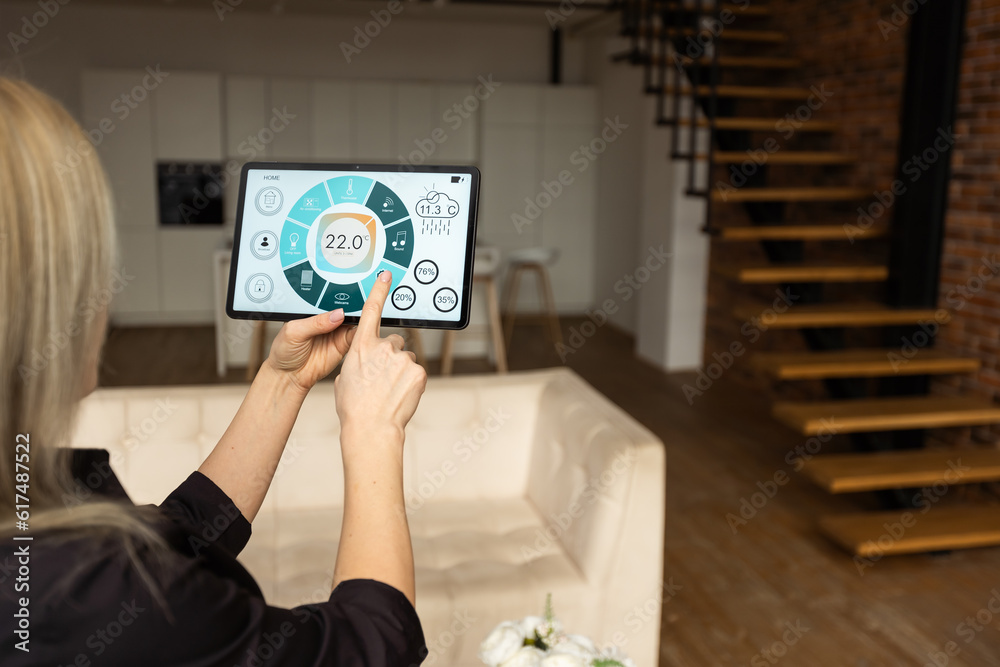 Obraz premium Woman at home using smart screen, automation domestic system