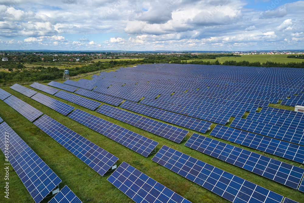 Aerial view of big sustainable electric power plant with many rows of solar photovoltaic panels for producing clean electrical energy. Renewable electricity with zero emission concept Aerial view of big sustainable electric power plant with many rows of solar photovoltaic panels for producing clean electrical energy. Renewable electricity with zero emission concept