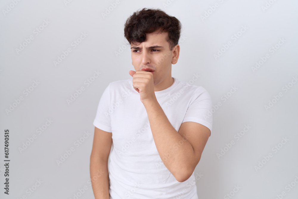 Young non binary man wearing casual white t shirt feeling unwell and coughing as symptom for cold or bronchitis. health care concept. Young non binary man wearing casual white t shirt feeling unwell and coughing as symptom for cold or bronchitis. health care concept.