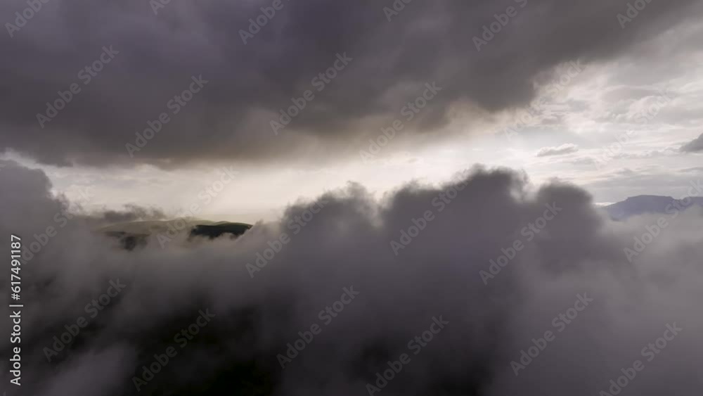 Epic hyperlapse aerial view low flying above the clouds at sunset in the mountains. Beautiful rays of the sun break through the clouds when the weather changes. background weather meteorology Epic hyperlapse aerial view low flying above the clouds at sunset in the mountains. Beautiful rays of the sun break through the clouds when the weather changes. background weather meteorology