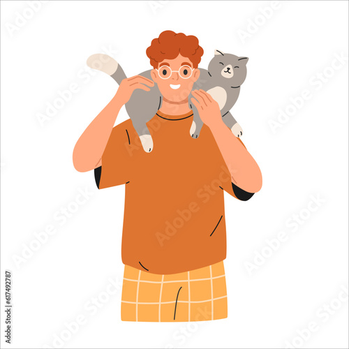 Cute happy cat lying on owners shoulder. Smiling man holding cute adorable kitty.