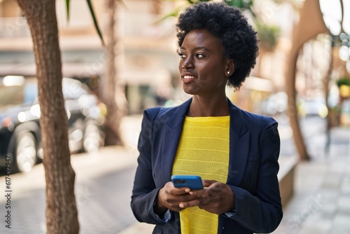 Young african american woman business executive using smartphone at street © Krakenimages.com