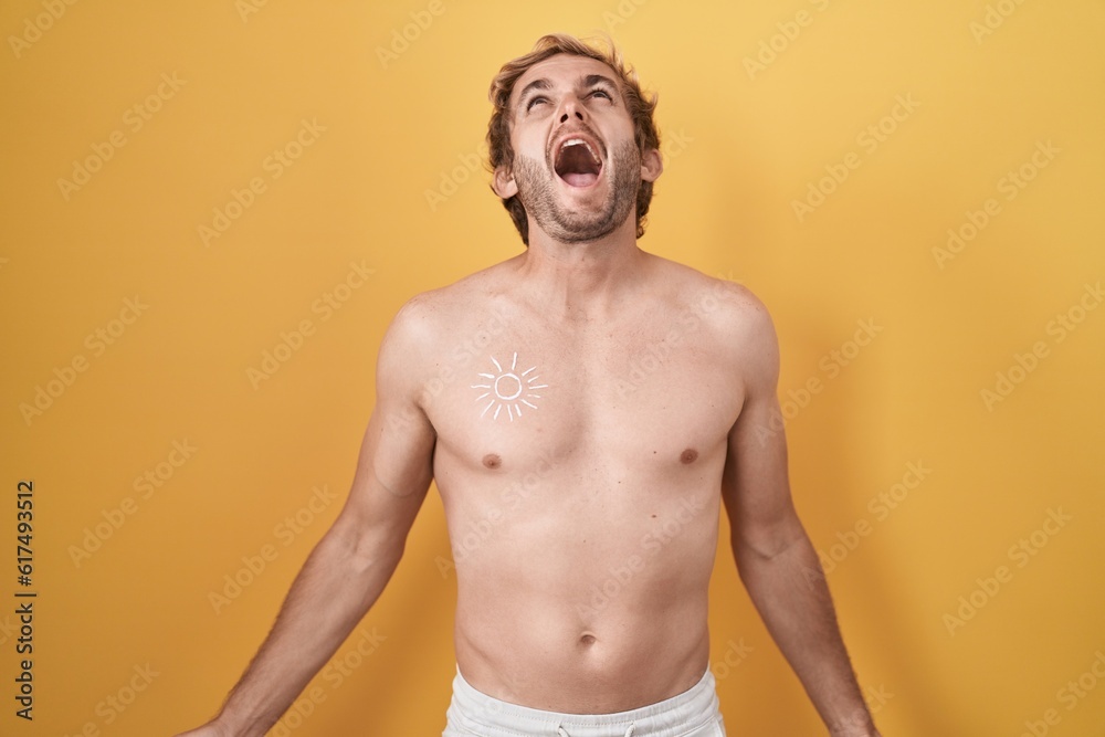 Caucasian man standing shirtless wearing sun screen angry and mad screaming frustrated and furious, shouting with anger. rage and aggressive concept.