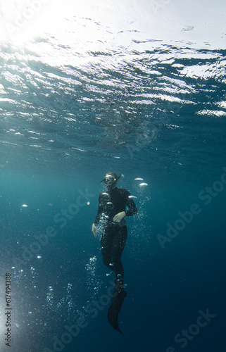 Free diver swimming up on water surface © Jag_cz