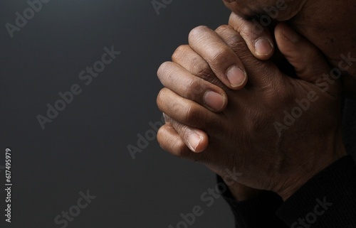 man praying to god with hands together Caribbean man praying with white background stock photo 