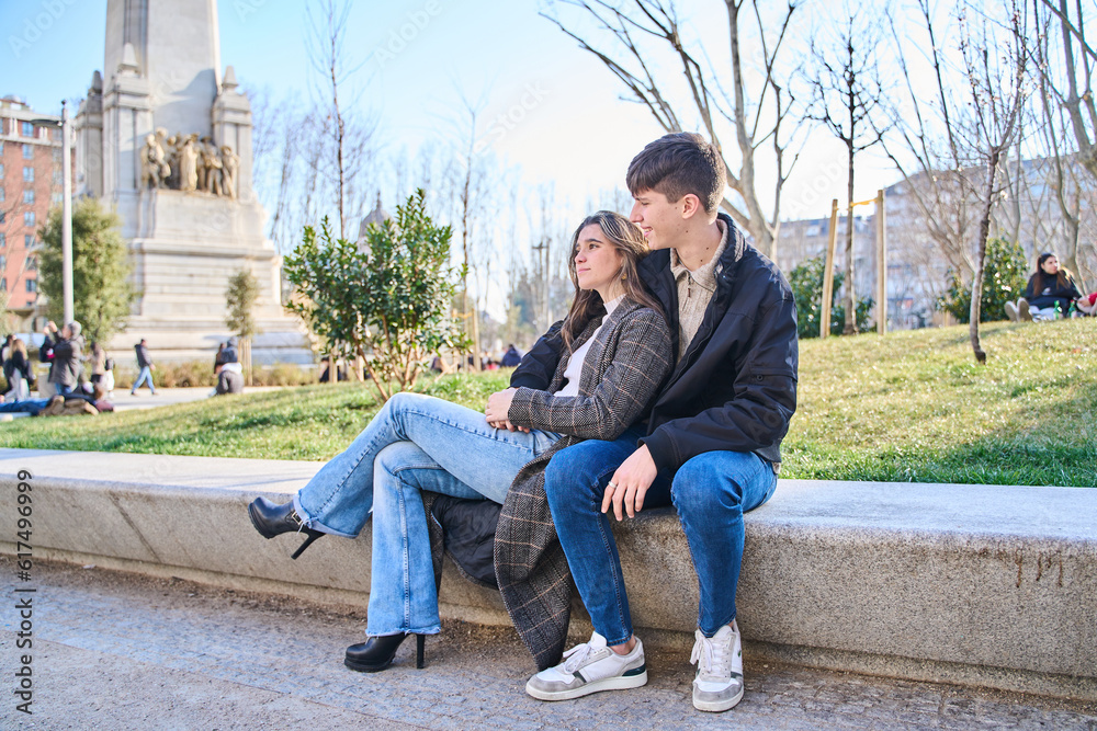 young couple sitting on a bench in the city. couple hugging and resting.