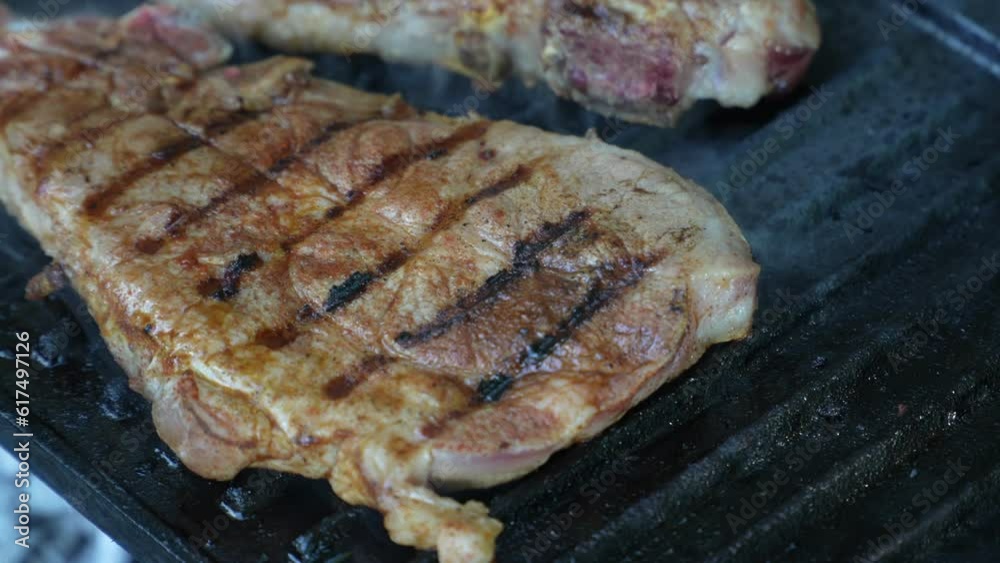 Fresh pork meat on the grill close up hand held video Fresh pork meat on the grill close up hand held video