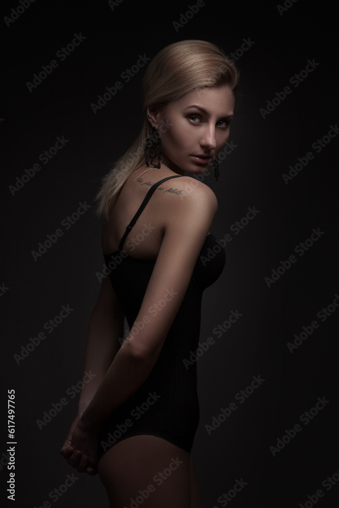 Sexy woman in black swimsuit isolated on dark background Sexy woman in black swimsuit isolated on dark background