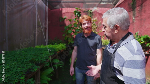 Fotografie, Obraz Senior horticulturist professional speaking with customer in plant store backyard