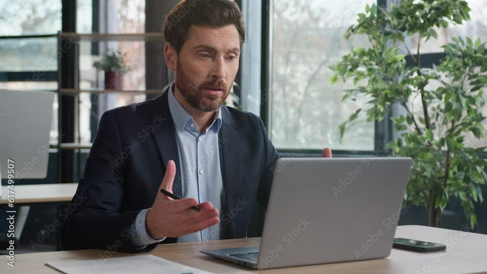 Serious caucasian businessman talking video call laptop in office man entrepreneur leader hr manager conduct remote chat interview at online conference using computer writing notes distance learning Serious caucasian businessman talking video call laptop in office man entrepreneur leader hr manager conduct remote chat interview at online conference using computer writing notes distance learning