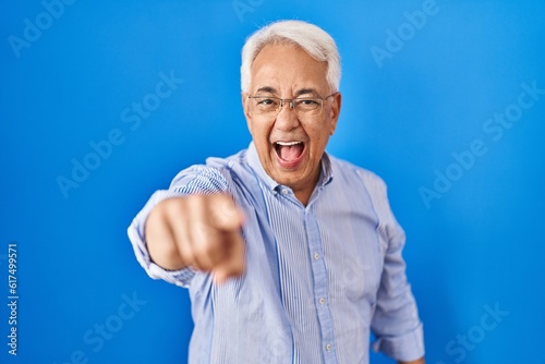 Hispanic senior man wearing glasses pointing displeased and frustrated to the camera, angry and furious with you © Krakenimages.com