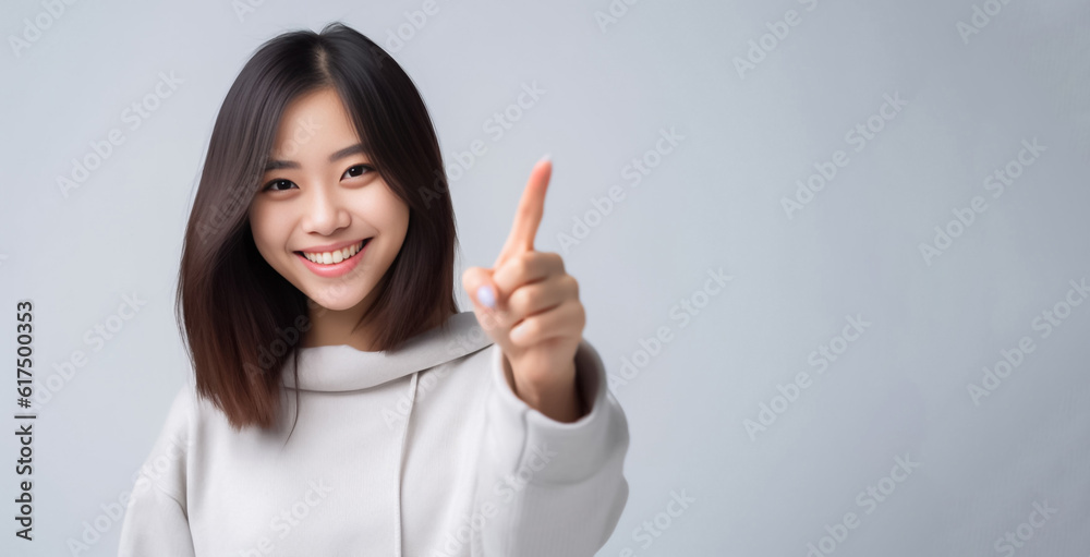 Pointing finger of an Asian girl highlights vacant space on a white background, making it a prime choice for a promotional advertising banner. Generative AI. Pointing finger of an Asian girl highlights vacant space on a white background, making it a prime choice for a promotional advertising banner. Generative AI.