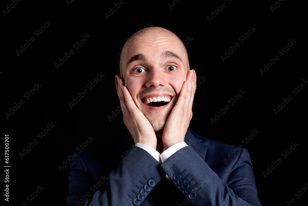 Studio portrait of young smiling man against black background. Studio portrait of young smiling man against black background.