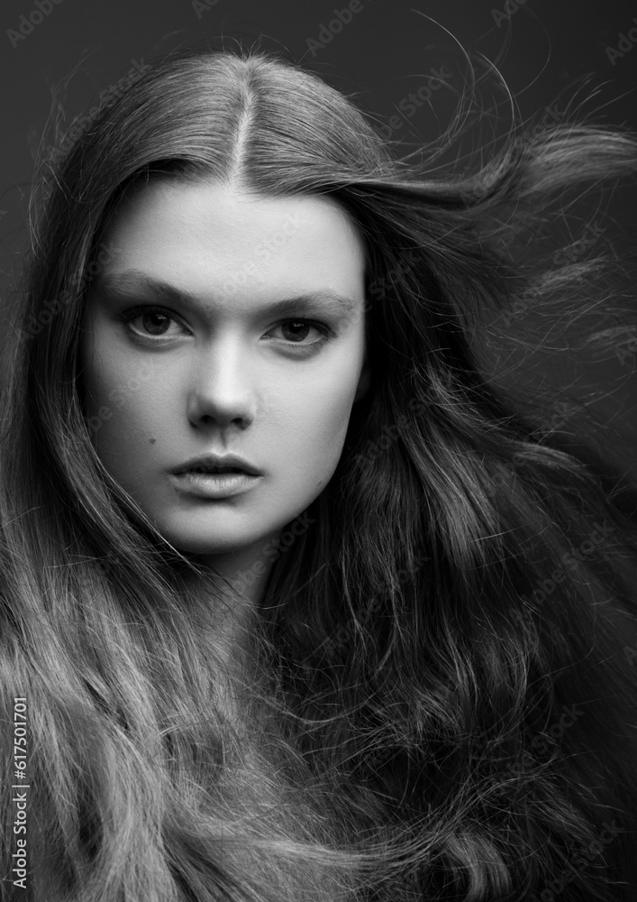 Portrait of beautiful young girl with long hair on grey background black and white Portrait of beautiful young girl with long hair on grey background black and white