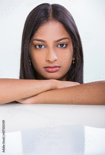 Portrait of a beautiful young Indian Asian woman or girl resting on her hands