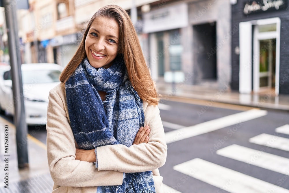 Young woman smiling confident standing with arms crossed gesture at street