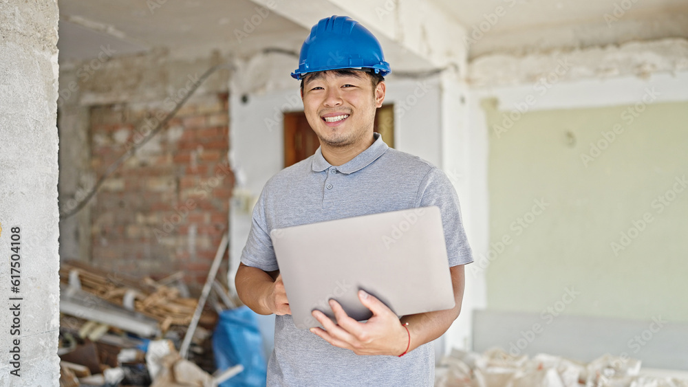 architect using laptop smiling at construction site architect using laptop smiling at construction site