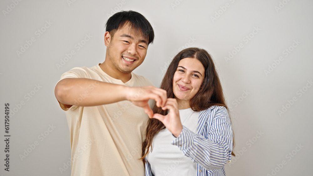 Man and woman couple smiling confident doing heart gesture over isolated white background Man and woman couple smiling confident doing heart gesture over isolated white background